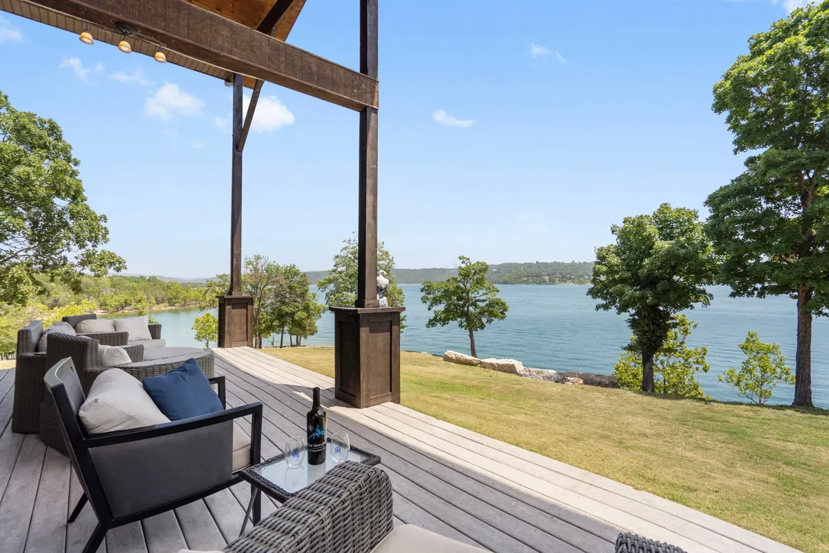 A peaceful outdoor seating area overlooking the lake, complete with a bottle of wine on the table. The setting suggests relaxation after a day of adventure, with sunset colors reflected on the water and a tranquil mood perfect for unwinding.