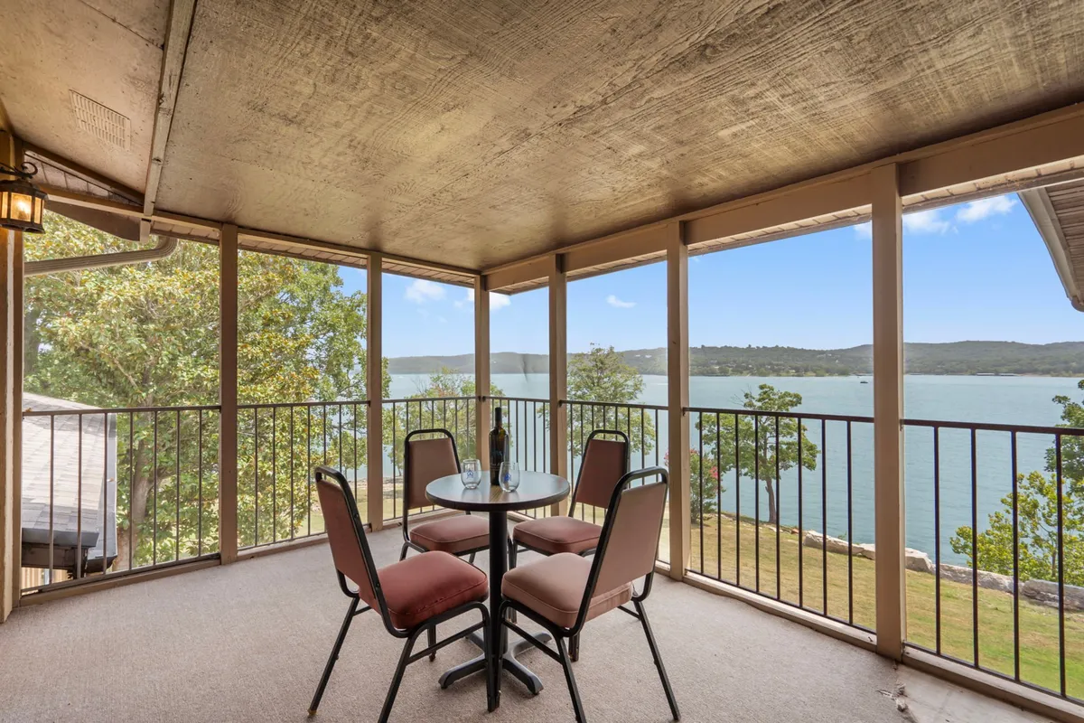 A peaceful outdoor balcony scene with a table set for drinks or dining, overlooking the lake. The view provides a sense of relaxation and connection to nature, ideal for both summer evenings and quieter moments in other seasons.